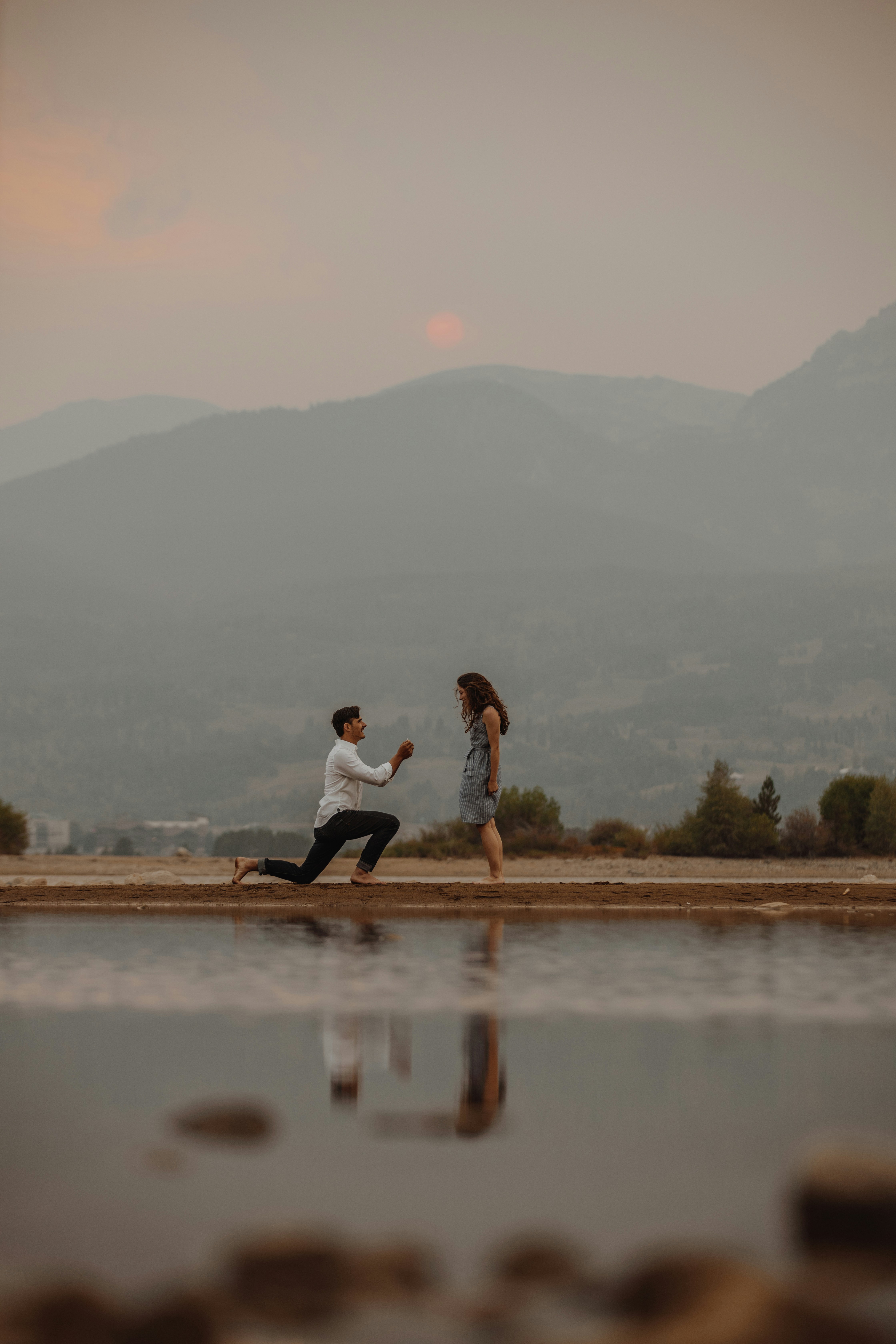 Wedding proposal from a distance with engagement ring in hand